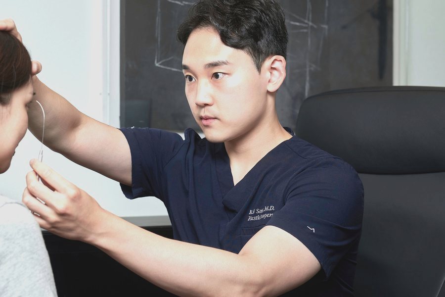 진료실에서 계측 기구로 눈 라인을 확인하는 고인석 원장