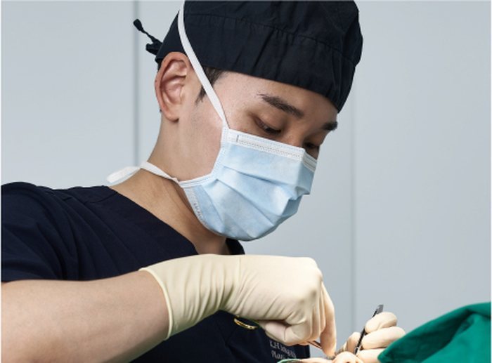 마스크와 수술모를 착용하고 수술실에서 집도하는 고인석 원장