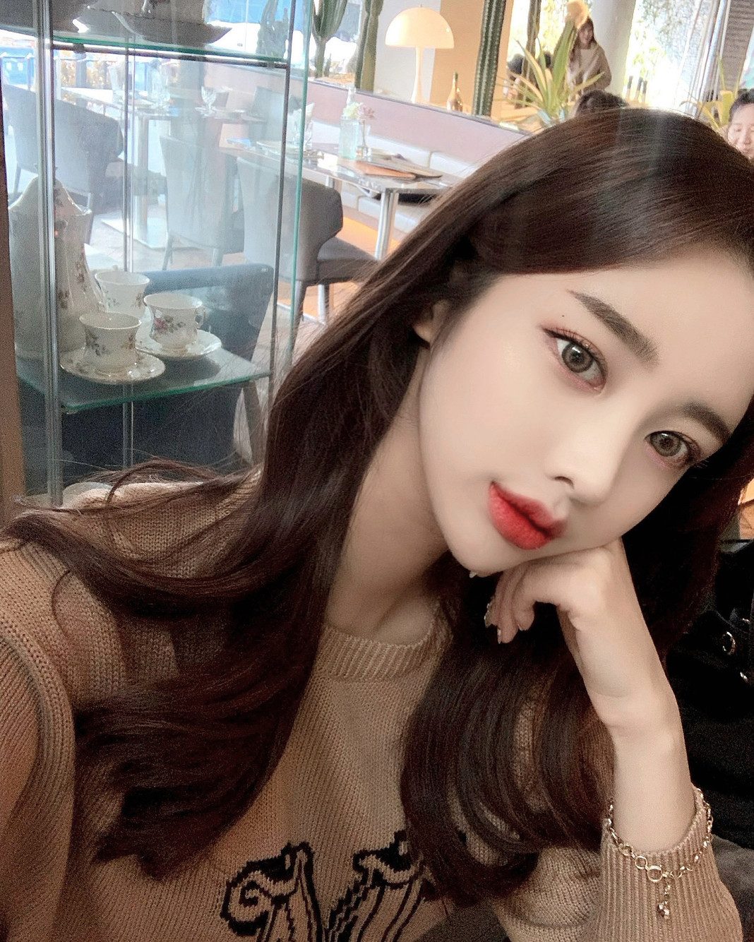 진열장 앞에서 턱을 괸 여성 셀피