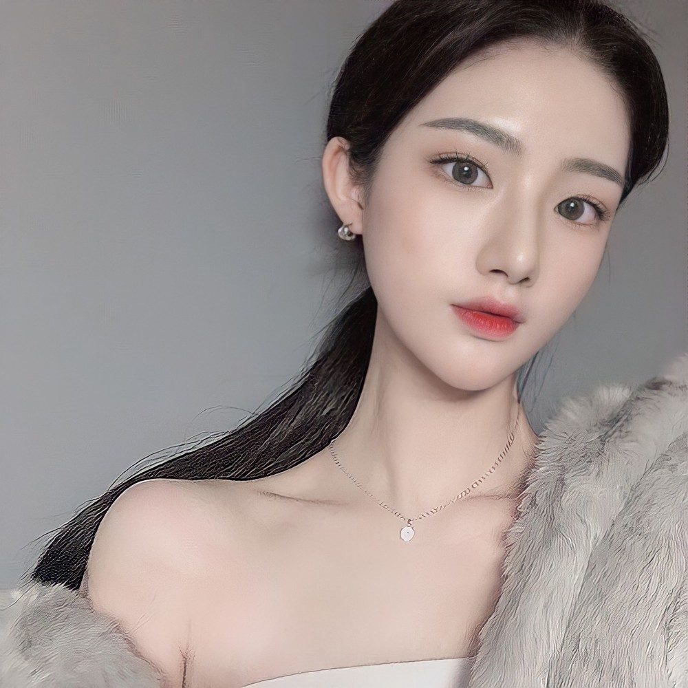 회색 배경 앞에서 정면을 바라보는 여성 셀피