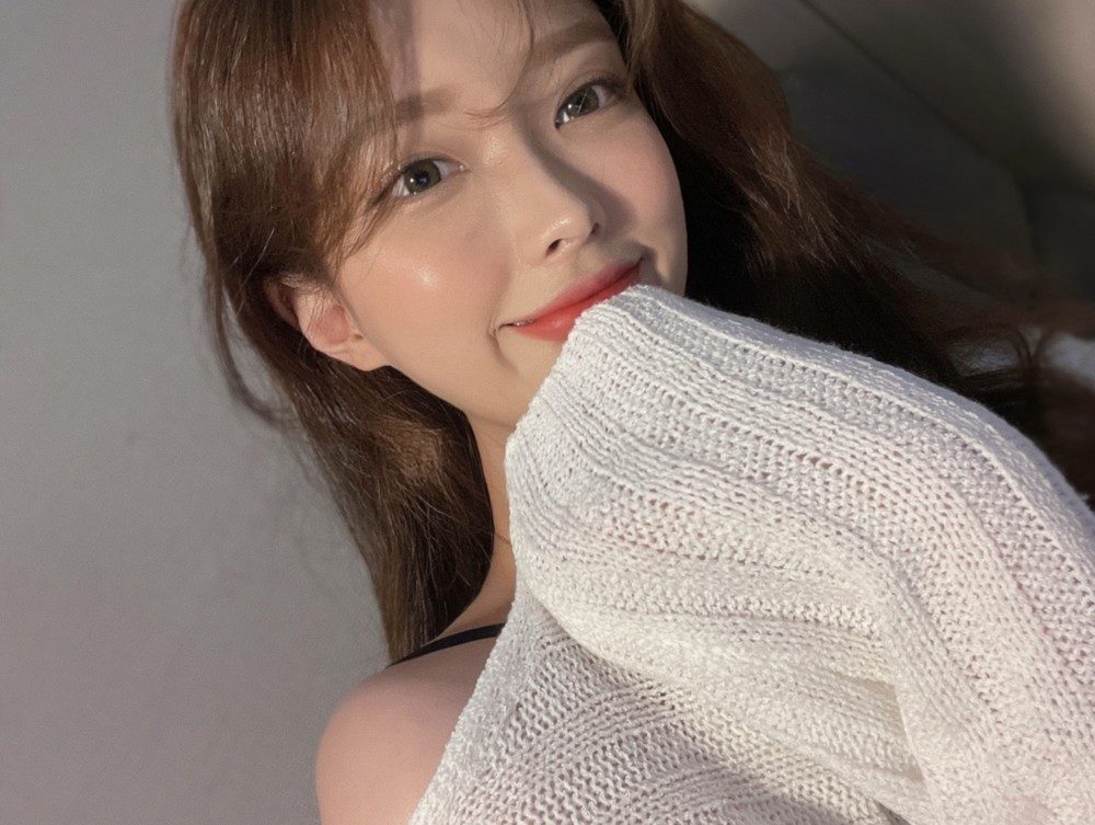 흰 니트에 얼굴을 기댄 여성 셀피